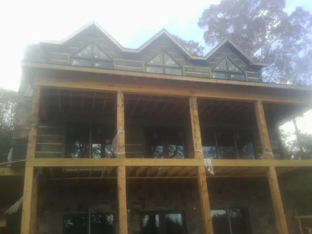Dormers and porch framing on a large log home under construction — Roof Coating work by our crew in Sherrills Ford