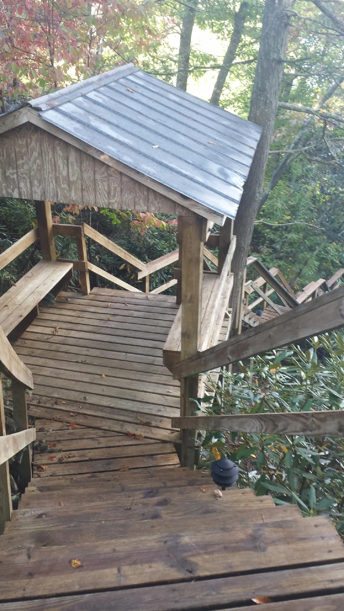 Metal roofed shelter over wooden steps on a wooded walkway — Skylight Repair & Installation work by our crew in Sherrills Ford