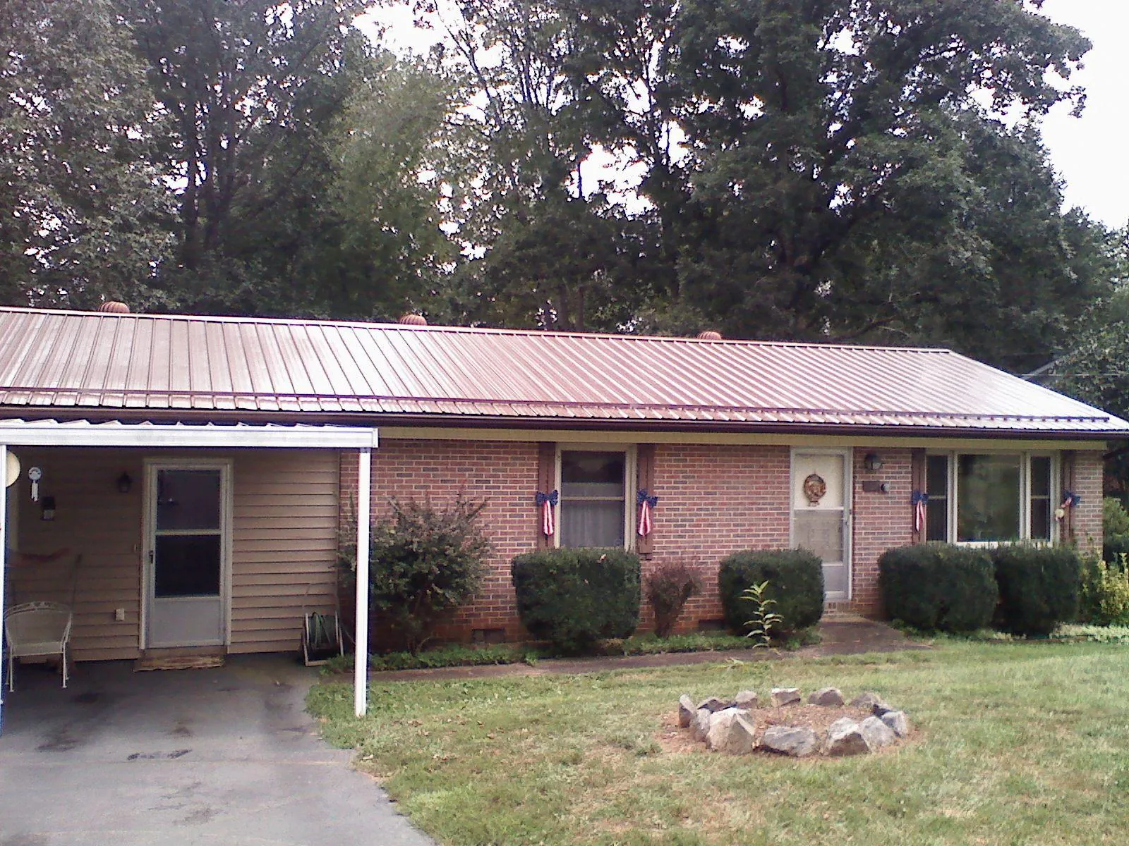 Bronze metal roof and carport on a brick ranch home — Roof Repair work by our crew in Sherrills Ford